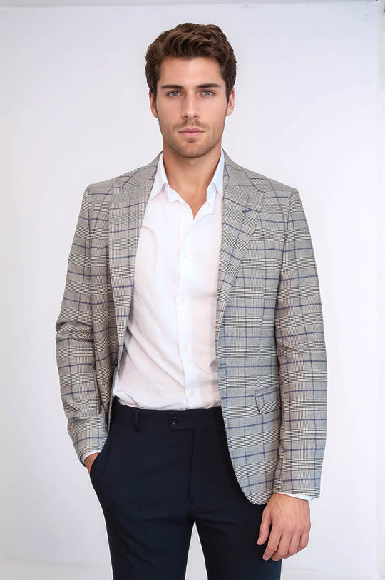 Man wearing a checkered blazer over a white shirt with dark pants on a white background