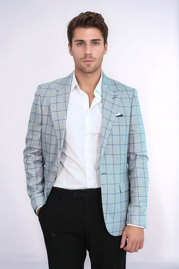 Man wearing a light blue checkered blazer over a white shirt with black pants on a white background