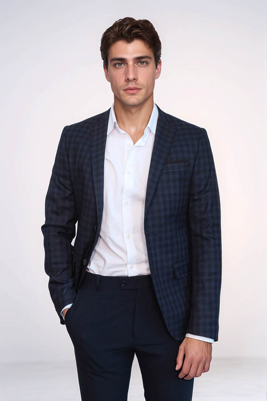 Man wearing a navy checkered blazer over a white shirt on a white background
