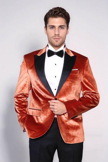 Man wearing a red velvet tuxedo with a black bow tie on a white background