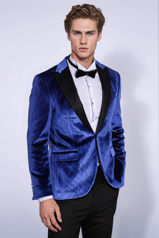 Man wearing a blue velvet tuxedo with a black bow tie on a white background