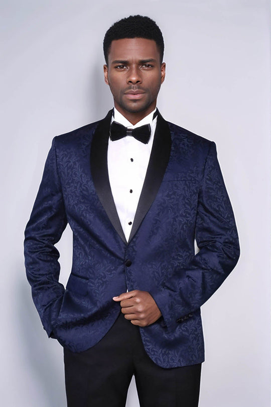 Man wearing a blue patterned tuxedo with a black bow tie on a white background
