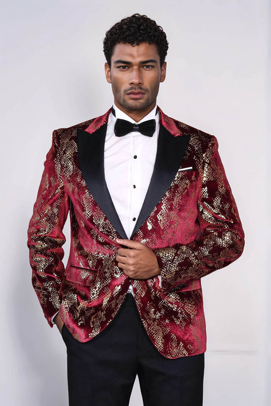 Man wearing a red patterned tuxedo with a white shirt and black bow tie on a white background