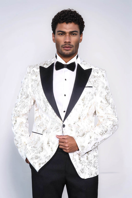 Man wearing a white lace dinner jacket with black lapels and bow tie on a plain background