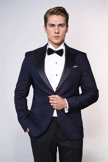 Man wearing a navy blue patterned tuxedo with a white shirt and black bow tie on a white background
