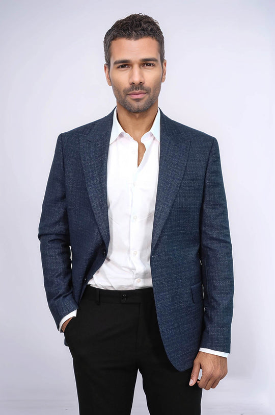 Man wearing a blue checkered blazer over a white shirt with black pants on a white background