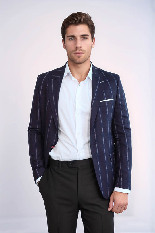 Man wearing a navy pinstripe blazer over a white shirt with a light gray background