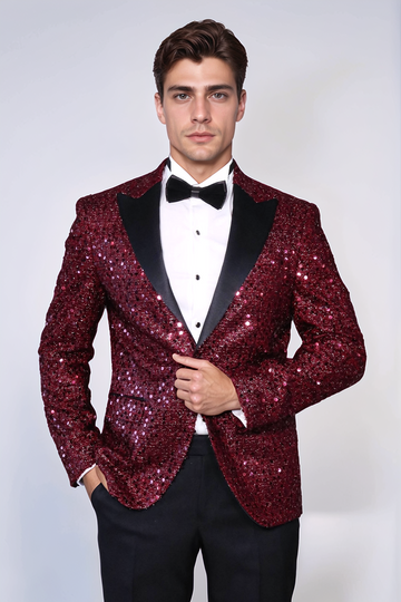 Man wearing a red sequin tuxedo with black lapels on a white background