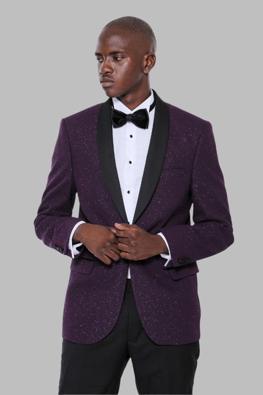 Man wearing a purple tuxedo with a black bow tie on a gray background