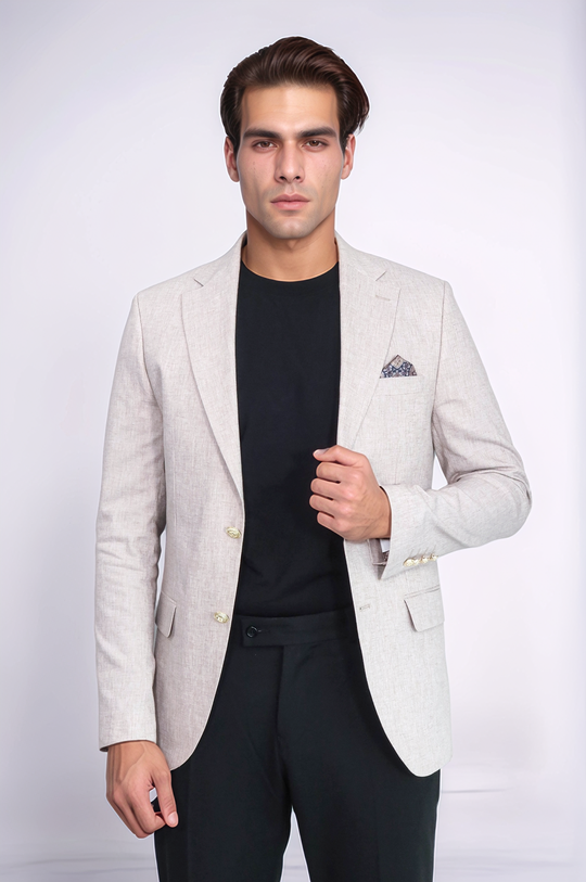 Man wearing a light gray blazer over a black shirt and pants on a white background