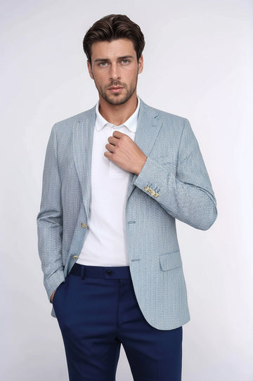 Man wearing a light blue checkered blazer over a white shirt and dark blue pants on a white background