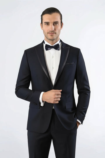 Man wearing a black tuxedo with a white shirt and black bow tie on a white background