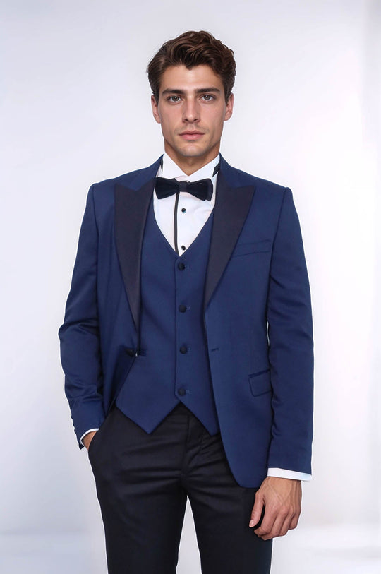 Man wearing a blue tuxedo with a white shirt and black bow tie on a white background