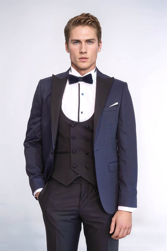 Man wearing a formal navy blue suit with a bow tie on a white background