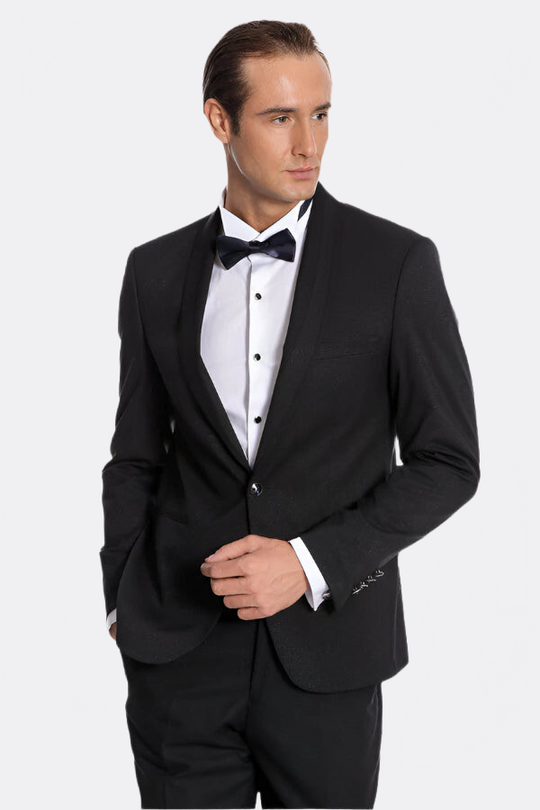 Man wearing a black tuxedo with a white shirt and black bow tie on a white background