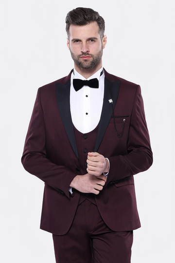 Man wearing a burgundy tuxedo with a white shirt and black bow tie on a white background