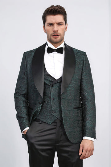 Man wearing a green patterned suit with a bow tie on a white background