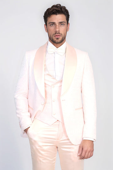 Man wearing a light pink suit with a white shirt on a plain background