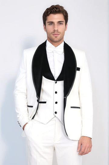 Man wearing a white tuxedo with black lapels against a light gray background