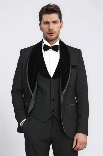 Man wearing a black tuxedo with a white shirt and black bow tie on a light gray background