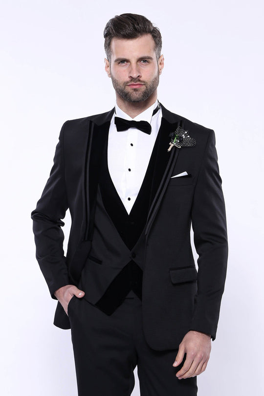 Man wearing a black tuxedo with a white shirt and bow tie on a white background